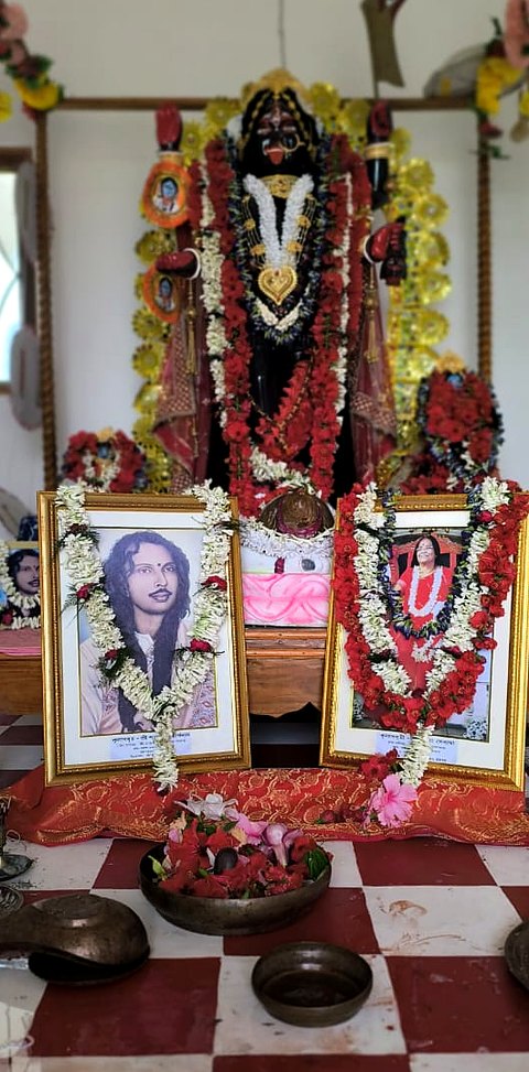 Portraits of Param Guruji and Guruma placed before Maa Kali in the shrine.